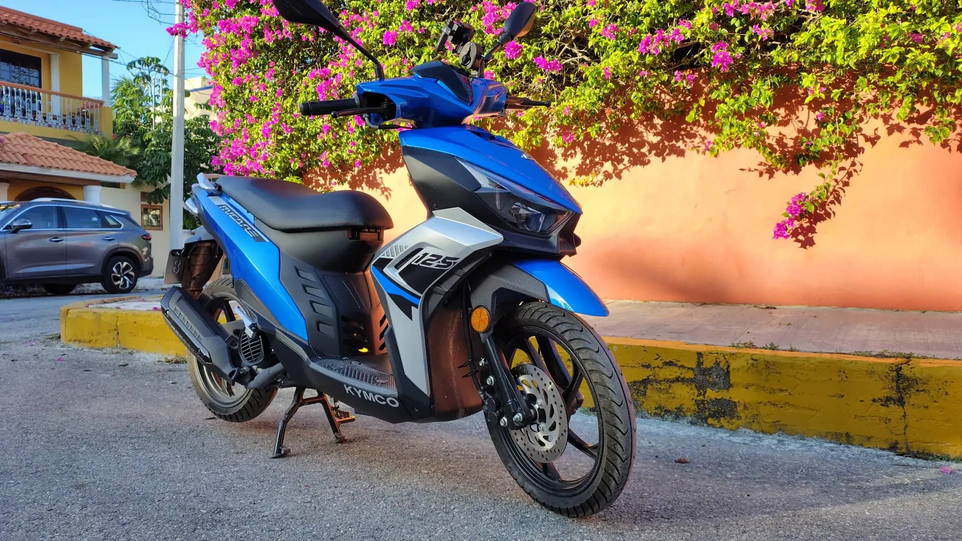 Kymco Micare 125 rental scooter under pink bougainvillea in Puerto Morelos